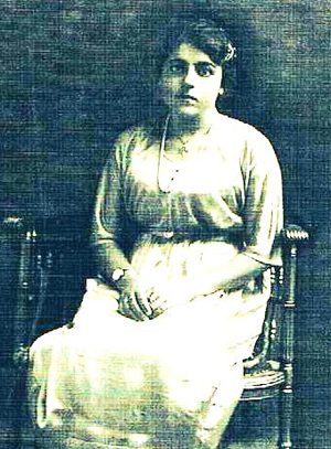 Historic portrait of a young woman seated in a chair.