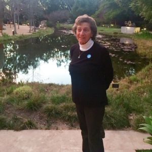 Kay Mouradian standing beside a garden pond.